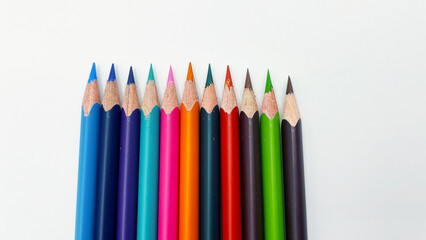 Colorful sharpened pencils are lined up on the table.