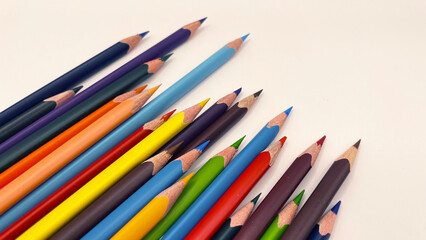 Colorful sharpened pencils are lined up on the table.