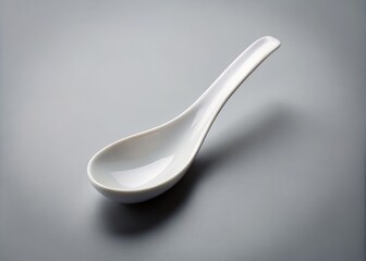 a photo image of a simple, white spoon with a slightly curved shape and rounded edges, placed on a plain gray background.