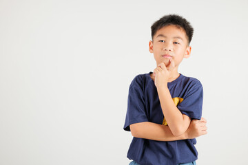 Portrait of an Asian kid boy deep in thought, standing with chin in hand, pondering a question. Studio shot isolated on white with ample copy space, primary child portraying contemplative expression © sorapop