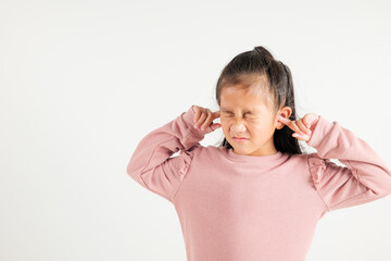 Asian young kid girl expression of pain and frustration is evident as she covers ears and closes eyes with fingers to escape the loud noise in studio shot isolated white background, kindergarten child
