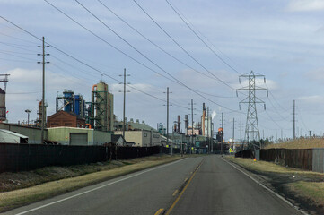 Obraz premium A road leading to a steel mill under high voltage power cables