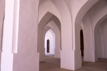A long, narrow hallway with white arches on either side