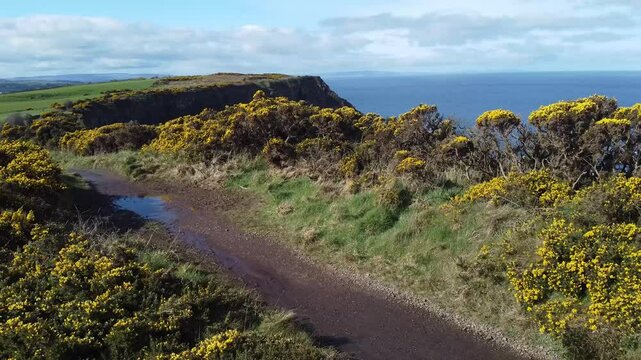 Wide panorama video of cliffs and hexagonal stones or pillars at Giants causeway in northern ireland, majestic basalt pillars at the beach on a cloudy day. Wide view of area..
