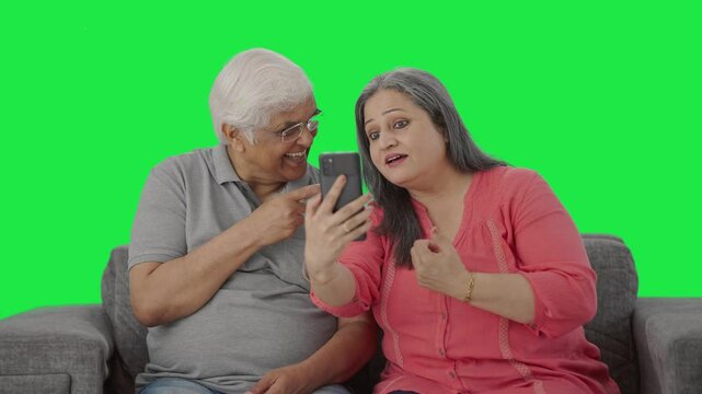 Happy Old Indian couple talking on video call Green screen