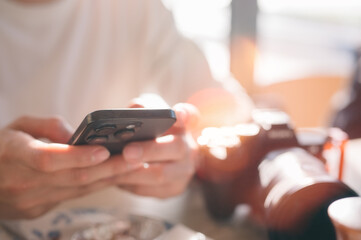 Social media marketing concept. Man hand using smartphone typing, chatting conversation in chat box icons pop up checking social media in cafe having a relaxing momen