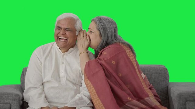 Happy Old Indian wife telling a secret to her husband Green screen