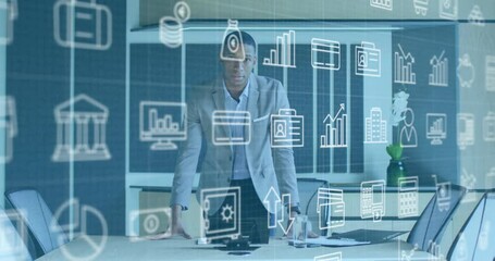 Businessman in office with data analytics and business icons animation over him