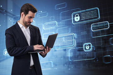 Young european businessman using laptop with creative encrypted code hologram on blurry office background. Blockchain network and technology concept. Double exposure.