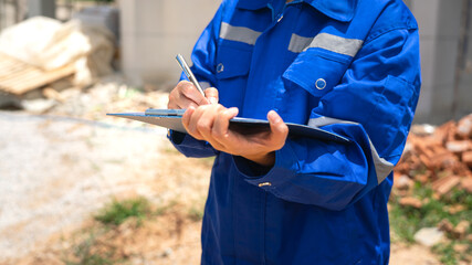 An architect is checking on house building quality checklist form to inspecting the progress with...