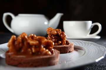Chocolate brownie with walnuts. Breakfast concept. The kettle is out of focus.Black background.