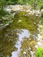The river runs along the rocky cliffs in the mountains