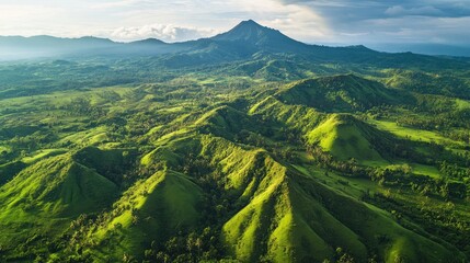 Aerial perspective of the rolling hills and volcanic peaks of the Kelud Volcano region in East Java.