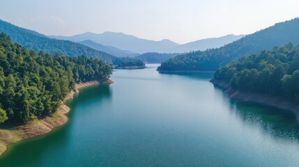 Fototapeta premium Aerial shot of the serene waters and surrounding forests of the Mae Ngat Dam in Chiang Mai, perfect for kayaking.