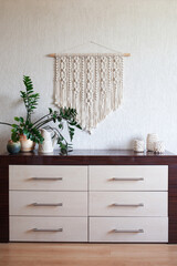 Macrame wall hanging  in the interior. 100% cotton handmade. ECO friendly modern knitting DIY natural decoration concept. Female hobby. .