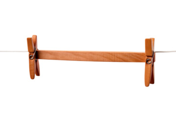 A vintage wooden clothespin hanging on a white clothesline, isolated on a white background