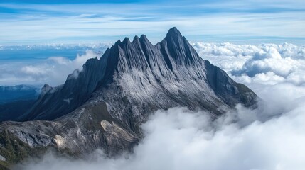 Obraz premium Top view of Mount Kinabalu's jagged granite peaks rising above swirling clouds in Sabah, Borneo.