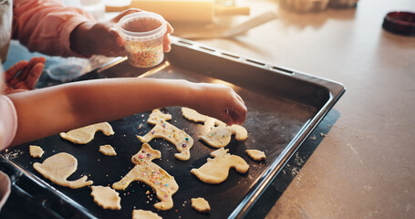 Cookies, hands and baking with tray for sprinkles, food and child in kitchen with snack recipe....