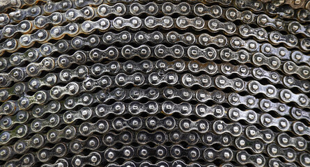 Old bicycle chain circle shape background. Used bike chain coiled in spiral textured . Machinery concept.