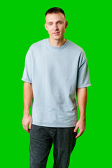 Young Man Standing Confidently Against Bright Green Background in Casual Attire