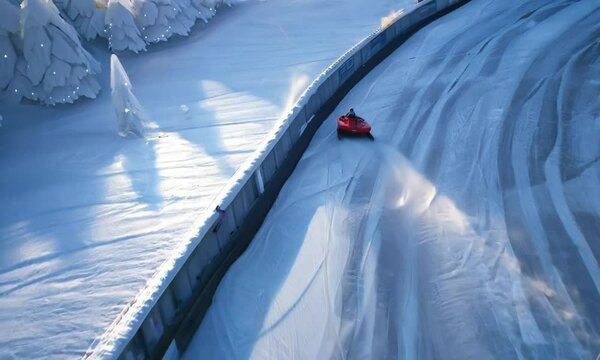 single bobsled speeding down an icy track surrounded by snow-covered trees in a winter landscape. The sharp turns and frozen scenery create a sense of speed and competition. Generative Ai