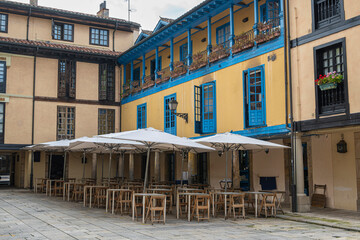 Terraza de restaurante bar con sillas, mesas y sombrillas en la hermosa plaza del Fontán en la...