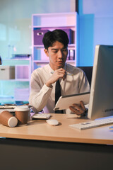 Fototapeta premium stressed asian male businessman working in the office.Man thinking too much work concept in the office, employees working overtime.