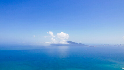 A serene seascape with a distant island under clear blue skies, perfect for travel and relaxation concepts