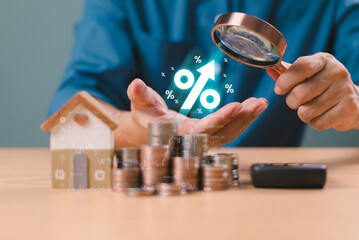 Interest rate financial, mortgage rates rise concept. Businessman use magnifying glass find...