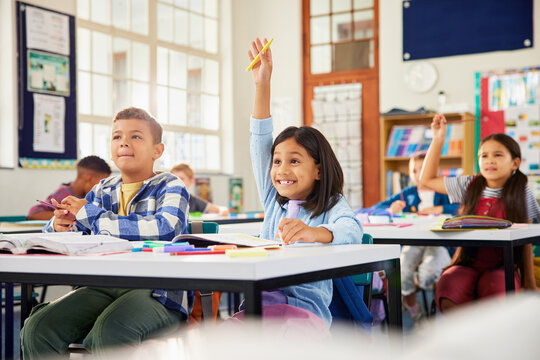 Girl raising hand in classroom: she knows the answer! - Powered by Adobe