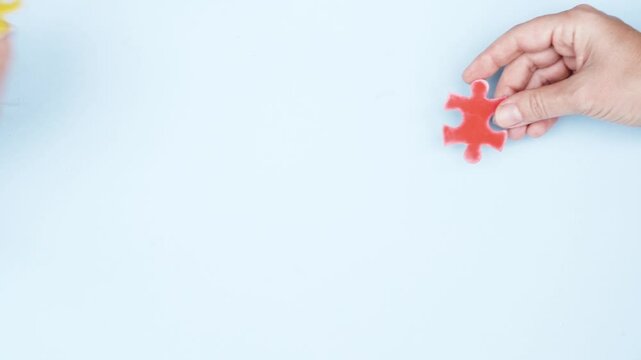 international autism awareness day - hand placing pice of jigsaw puzzles