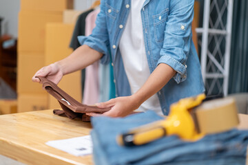 Young Asian man, distributor, online shop owner, small business owner, standing in warehouse and preparing to ship goods, with parcel boxes.