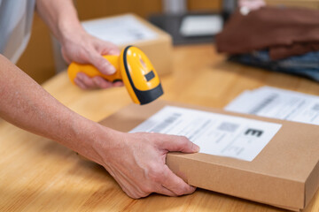 Young Asian man, distributor, online shop owner, small business owner, standing in warehouse and preparing to ship goods, with parcel boxes.