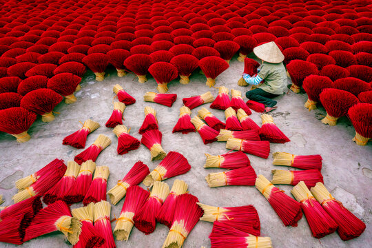 View of colourful joss sticks drying under the sun with dedicated workers in Quang Phu Cau village, Hanoi, Vietnam.