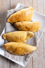 Pumpkin empanadillas for Halloween or Thanksgiving's Day on wooden table. Top view