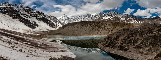 View of serene Fairy Meadows National Park with majestic mountains and a pristine lake under a dramatic sky, Gilgit-Baltistan, Pakistan.