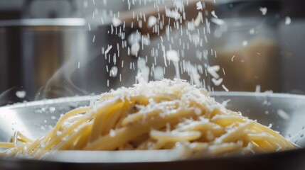 A close-up of pasta being topped with a snowfall of freshly grated cheese, highlighting an irresistible, mouth-watering moment.