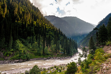 View of beautiful mountainous landscape with a winding river and lush green forest, Kashmir, Pakistan.