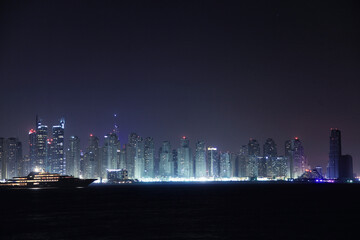 View of illuminated skyline with modern skyscrapers in a colorful desert city, Dubai, United Arab Emirates.