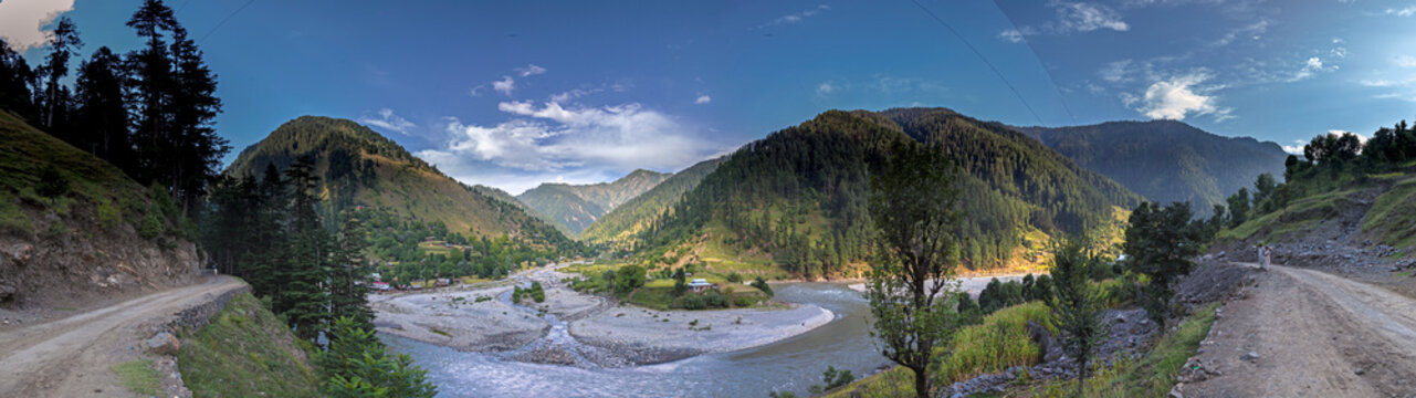 View of serene Neelum Valley with Salkhala River winding through lush mountains and trees, Kashmir, Pakistan.