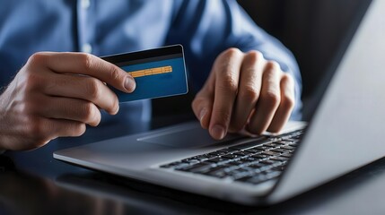 A person using a laptop holds a credit card, symbolizing online shopping and secure payment processes in a modern setting.