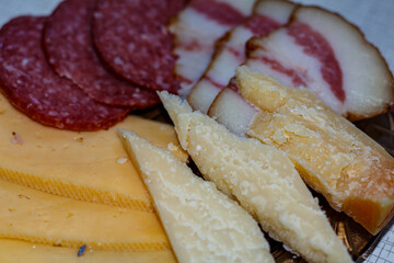 Sliced ​​cheese, sausage and lard on a plate.