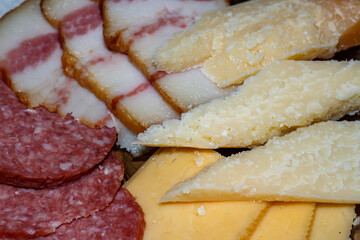 Sliced ​​cheese, sausage and lard on a plate.