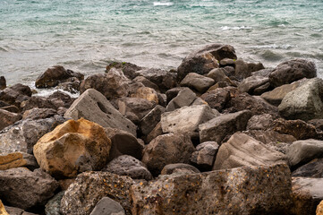 Sea waves on the stone seashore. Water splashes. Sea surface with waves. Abstract background of water flow in ocean, sea, river, lake. Seascape wallpaper.