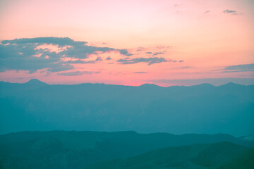 Silhouettes of mountains in a beautiful gentle haze, mountains at sunset or sunrise, natural background