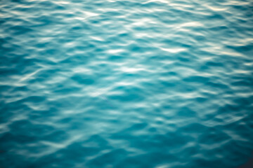 Water texture with waves and splashes from fish, natural natural water, sea background