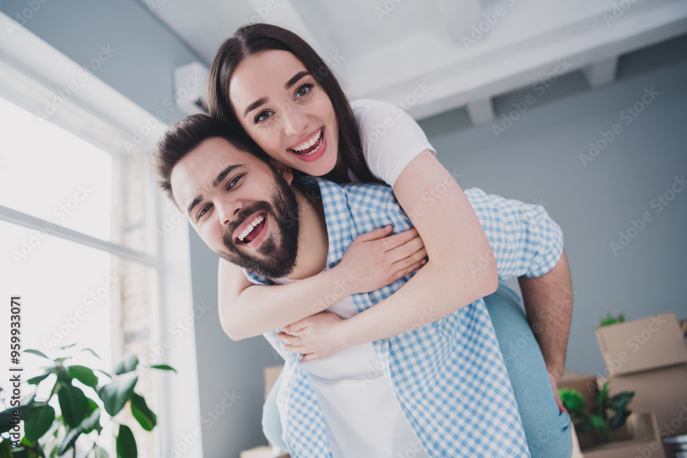 Poster Portrait of two young people piggyback relocating moving box package new apartment indoors