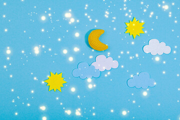 Fototapeta premium Weather symbols concept. Crocheted sun, clouds and moon. Handmade props, hobby, crafted decor