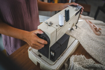 Close up on hands of unknown woman set up sewing machine