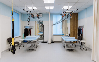 Rehabilitation room with therapy beds, suspension systems, and medical equipment for patient care